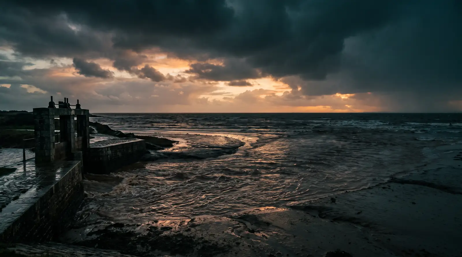 Un petit estuaire de la côte atlantique après une forte pluie d'automne, une eau brune qui s'étale sur la vasière sous des nuages qui se dissipent
