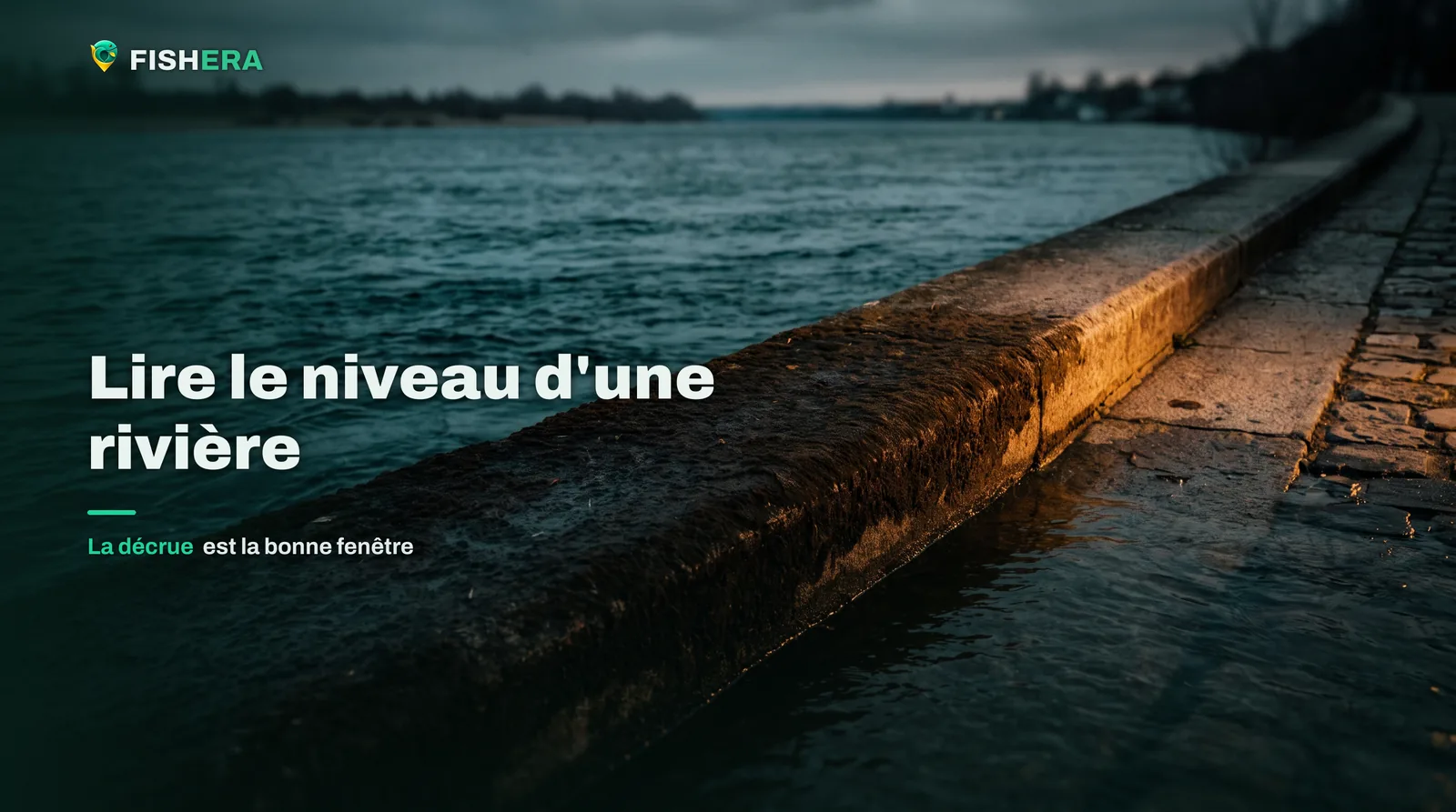 Un quai de pierre le long d'une rivière en décrue, une large bande sombre et mouillée marquant la hauteur atteinte par l'eau quelques heures plus tôt
